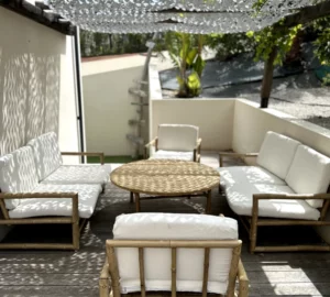 Réservation en ligne de l'appartement : Terrasse extérieure de l'appartement avec sa table basse, ses canapés et fauteuils.