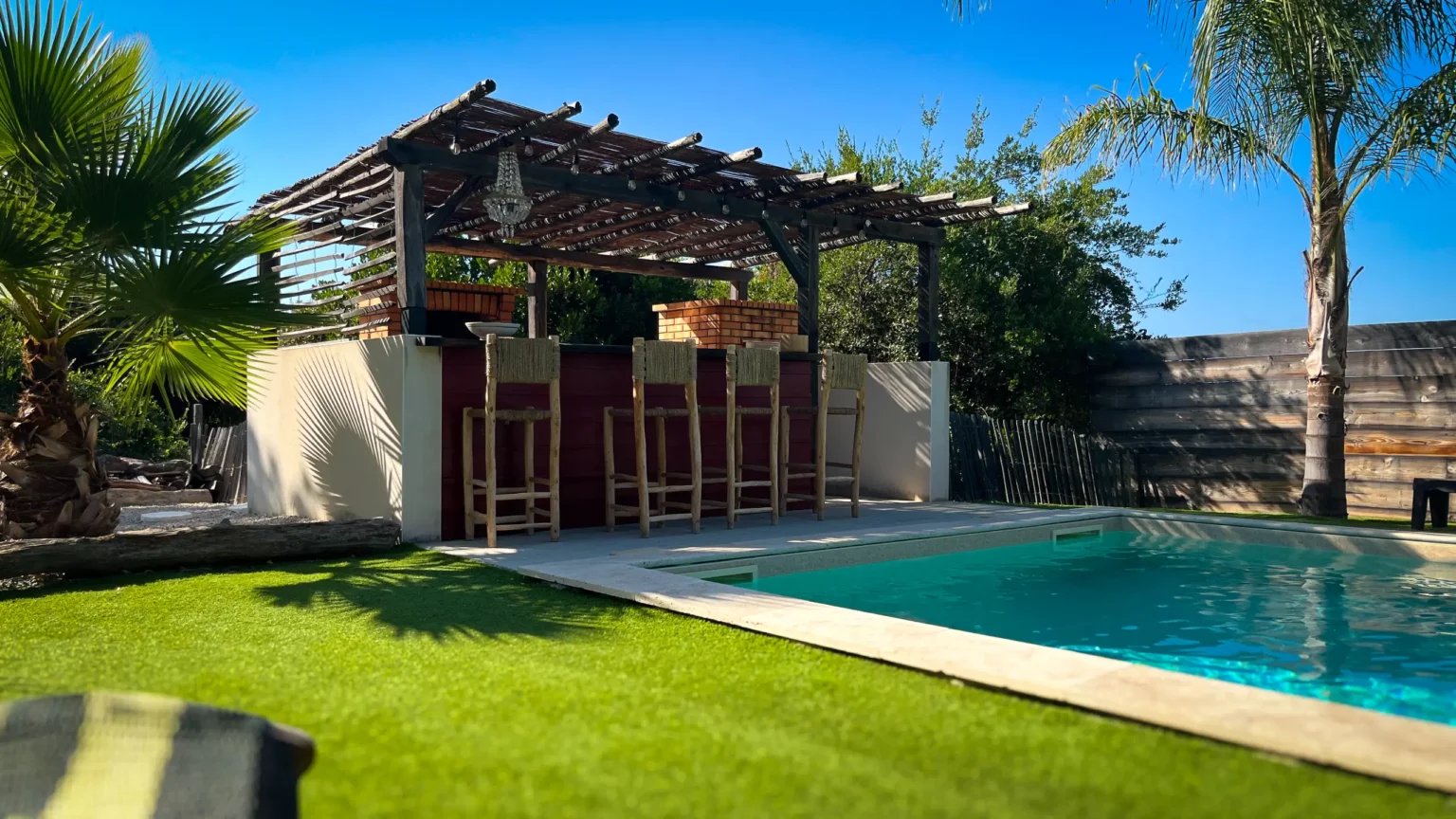 Vue sur la paillote de la villa avec son barbecue et son four à pizza surplombant la piscine
